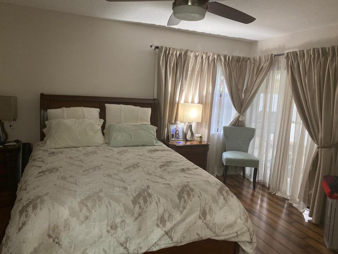 6657 Boca Hermosa Lane Boca Raton, FL 33433 - Photo 12 of 33 a bedroom with a bed a mirror and a large window