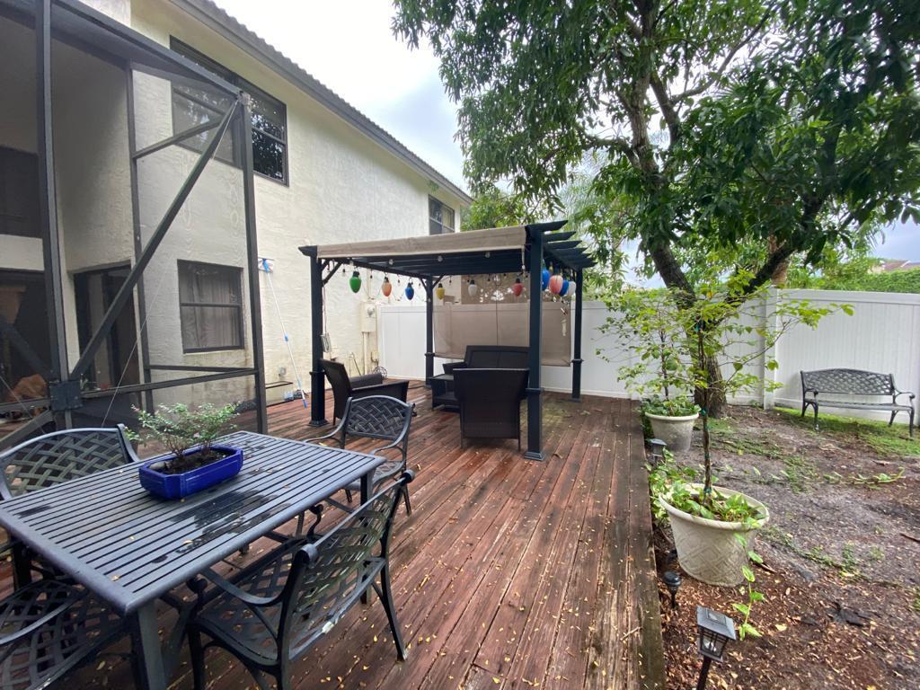 6657 Boca Hermosa Lane Boca Raton, FL 33433 - Photo 31 of 33 a view of a backyard with table and chairs potted plants and a large tree