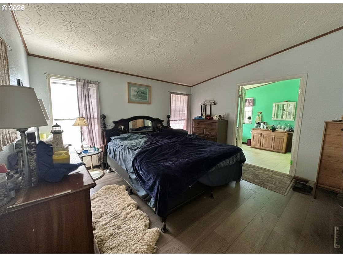 4821 Northeast 50th Street Neotsu, OR 97364 - Photo 8 of 19 a spacious bedroom with a bed a couch and dresser