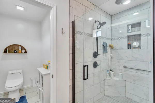 a bathroom with a toilet a sink a mirror a vanity and window