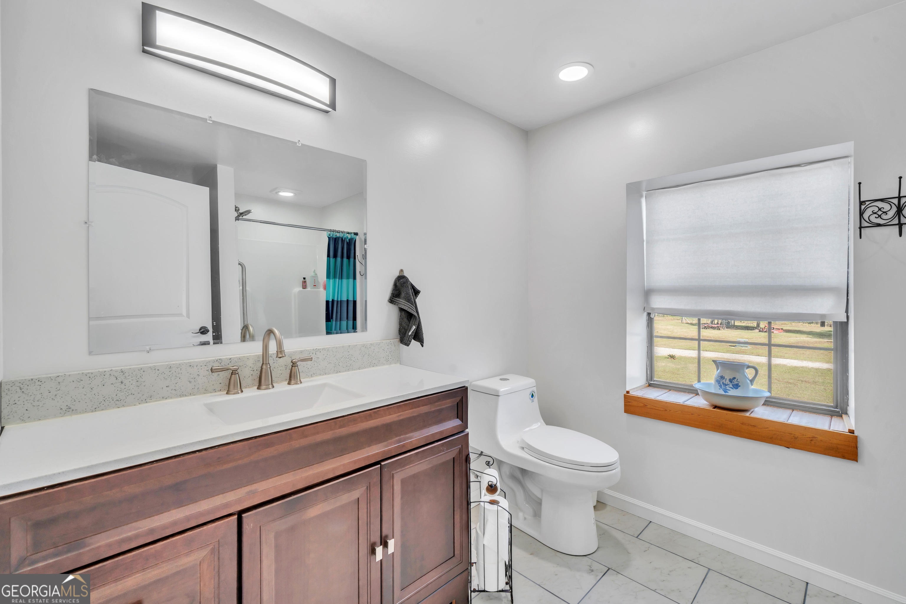 1864 Caulie Harris Road Adel, GA 31620 - Photo 31 of 78 a bathroom with a toilet a sink a mirror a vanity and window