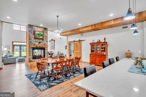 a dining room with furniture a chandelier and wooden floor