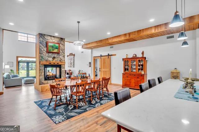 a dining room with furniture a chandelier and wooden floor
