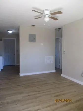 a view of an empty room with wooden floor