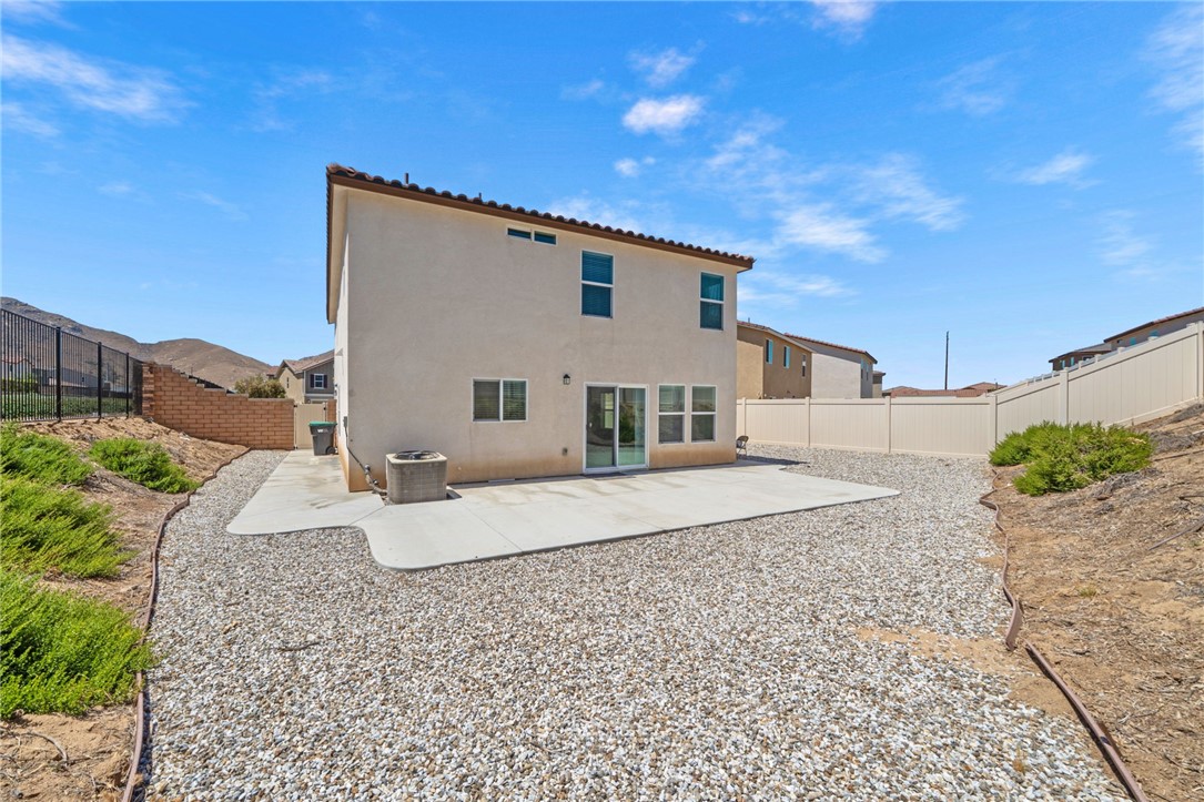 20130 Curaco Court Riverside, CA 92507 - Photo 39 of 43 Rear exterior with a large concrete patio and gravel-covered backyard.