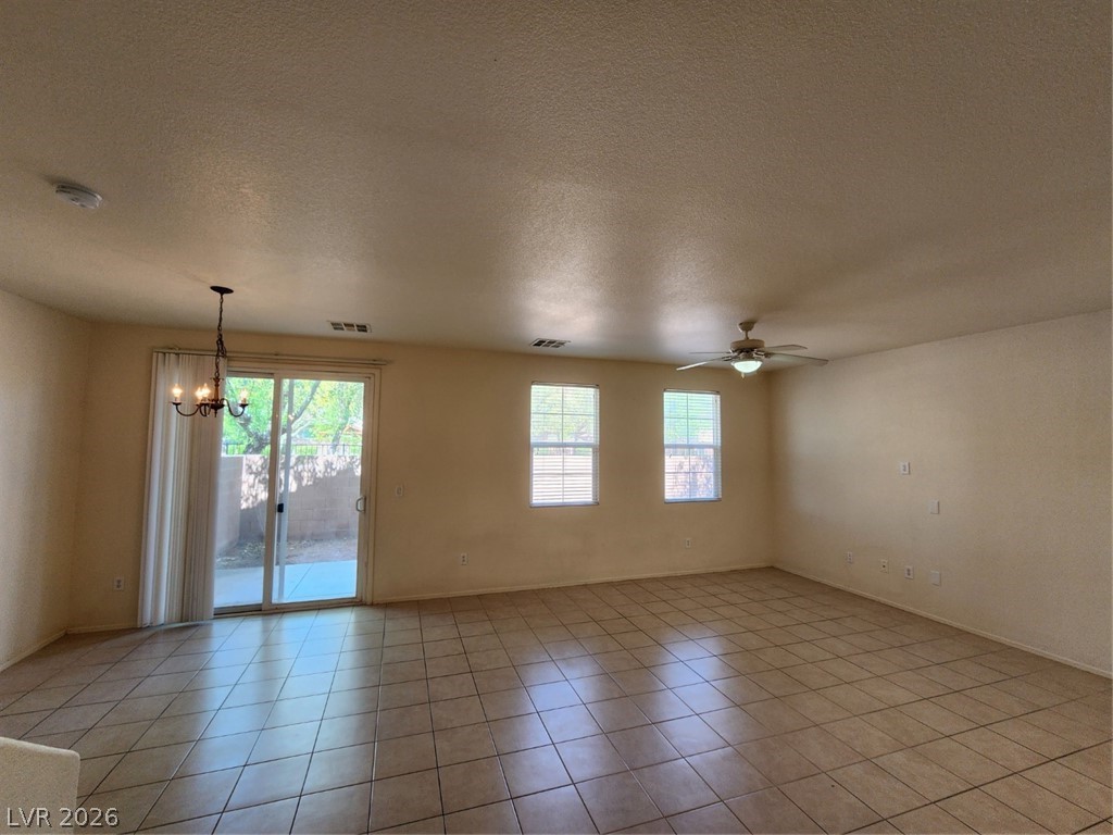 9132 Ripple Ridge Avenue, Unit 102 Las Vegas, NV 89149 - Photo 9 of 42 Unfurnished room with suspended lighting, a textured ceiling, ceiling fan, and light tile patterned flooring