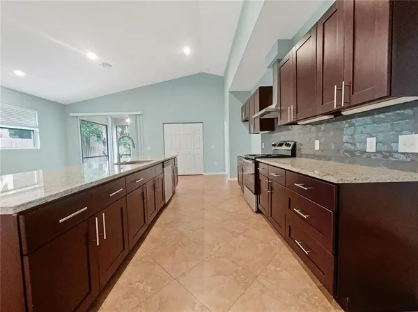 a kitchen with stainless steel appliances granite countertop wooden cabinets and sink