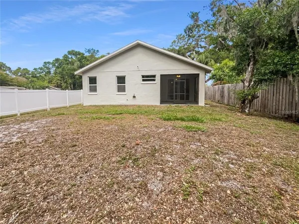 a view of backyard of house with green space