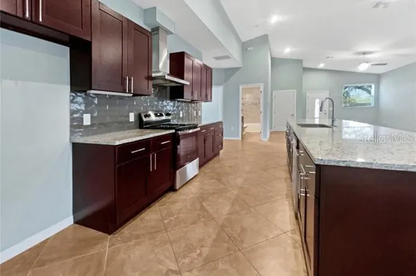 a large kitchen with stainless steel appliances granite countertop a sink and cabinets