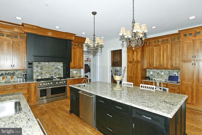 10208 Gary Road Potomac, MD 20854 - Photo 4 of 20 a kitchen with stainless steel appliances granite countertop a sink a stove and a wooden cabinets