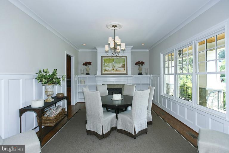 10208 Gary Road Potomac, MD 20854 - Photo 8 of 20 a dining room with furniture a fireplace and a chandelier