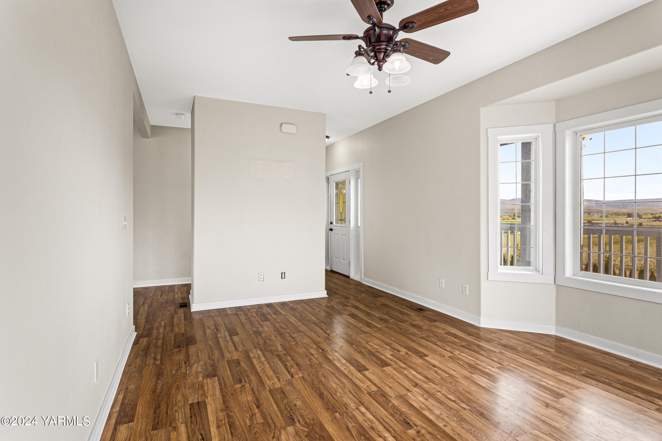 633 Hancock Road Cowiche, WA 98923 - Photo 16 of 53 an empty room with wooden floor chandelier fan and windows