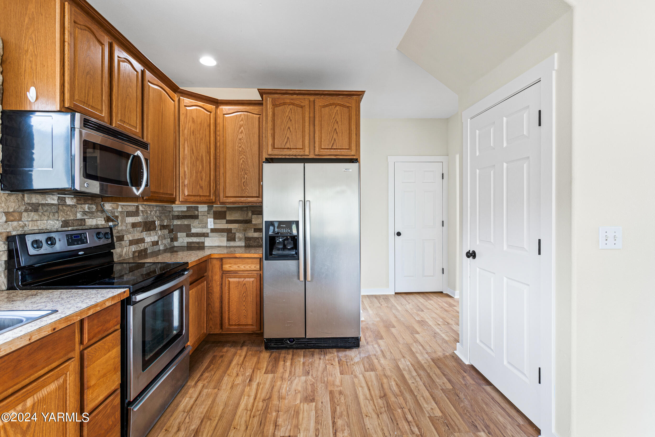 633 Hancock Road Cowiche, WA 98923 - Photo 24 of 53 a kitchen with stainless steel appliances granite countertop a refrigerator a stove top oven a sink and dishwasher with wooden floor