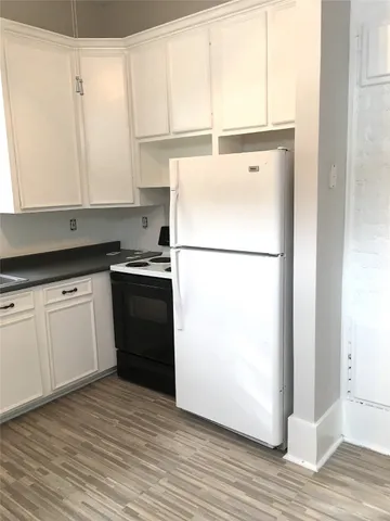 a kitchen with a refrigerator sink stove and cabinets