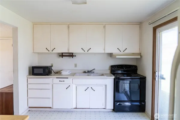 a kitchen with white cabinets and appliances