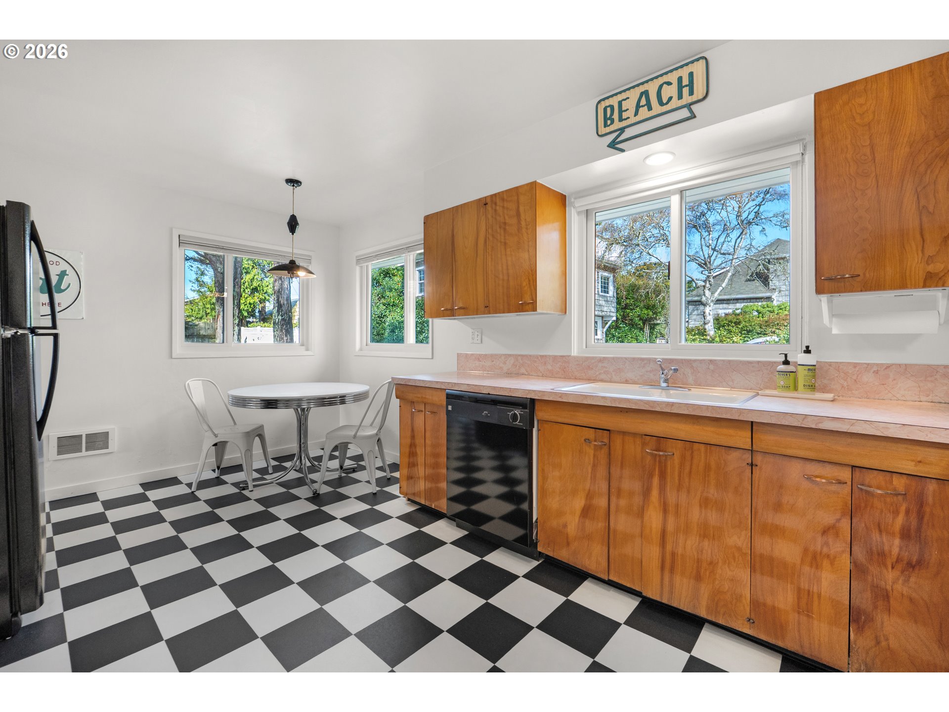 1210 South Columbia Street Seaside, OR 97138 - Photo 11 of 40 a living room with a black white checkered floor with a gaming machine and dining chairs