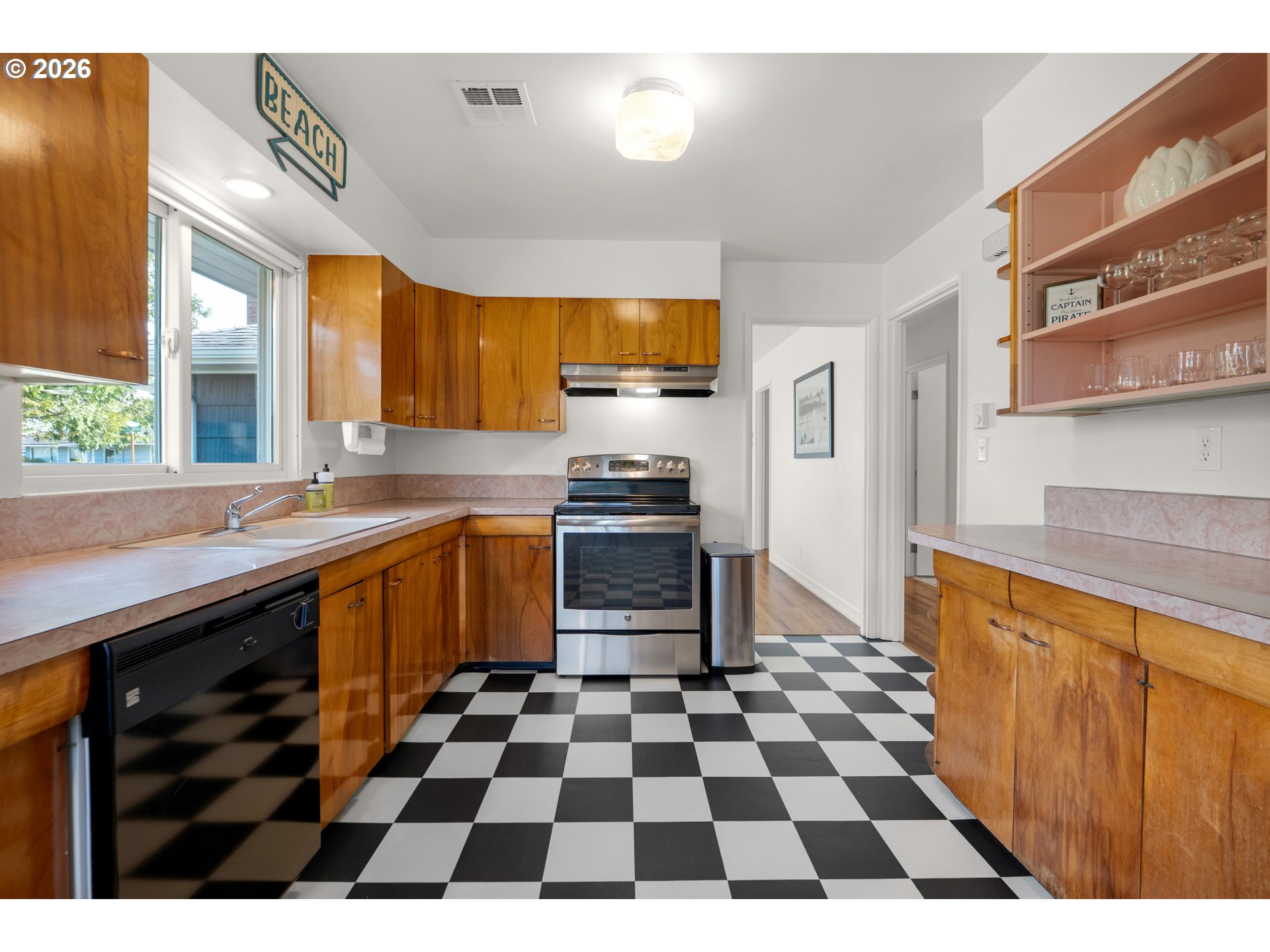 1210 South Columbia Street Seaside, OR 97138 - Photo 13 of 40 a kitchen with a checkered floor and white cabinets