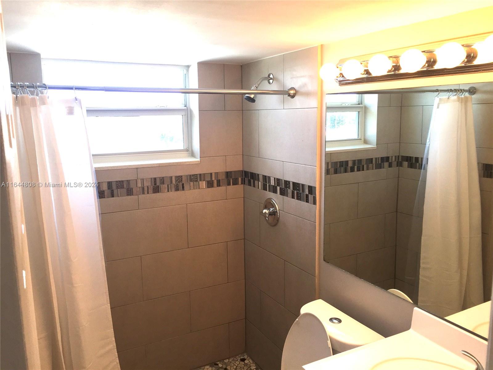 3075 Northwest 7th Street, Unit 401 Miami, FL 33125 - Photo 4 of 5 a bathroom with a bathtub and shower