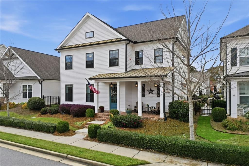 a front view of a house with a yard and potted plants