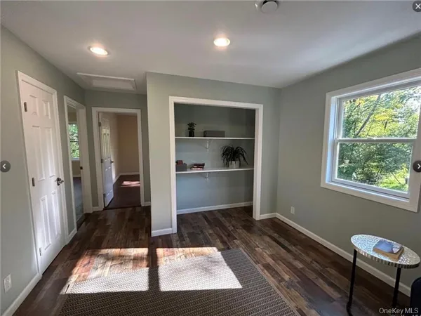 a view of a hallway with wooden floor and a cabinet