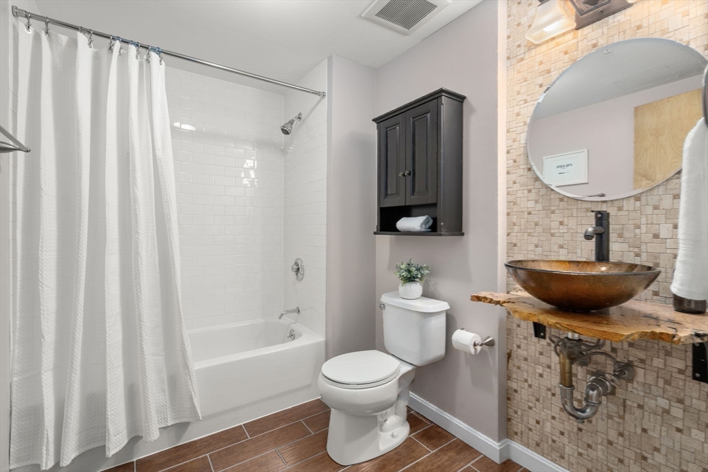 156 Porter Street, Unit 421 Boston, MA 02128 - Photo 14 of 29 a bathroom with a toilet a sink and a bathtub