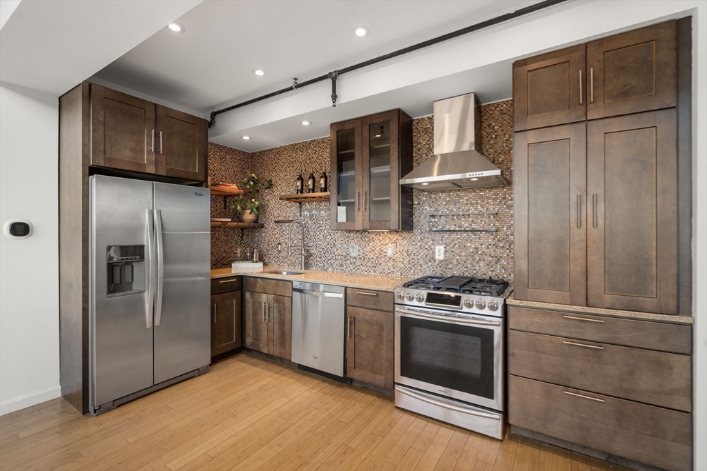 156 Porter Street, Unit 421 Boston, MA 02128 - Photo 6 of 29 a kitchen with granite countertop stainless steel appliances and wooden cabinets
