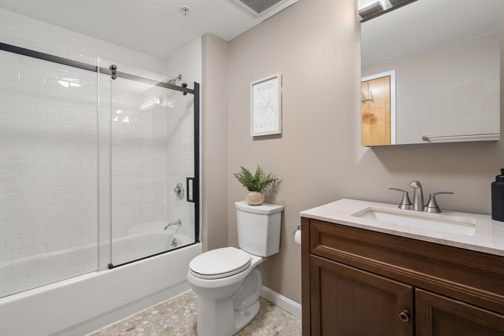 156 Porter Street, Unit 421 Boston, MA 02128 - Photo 10 of 29 a bathroom with a granite countertop sink toilet a mirror and shower
