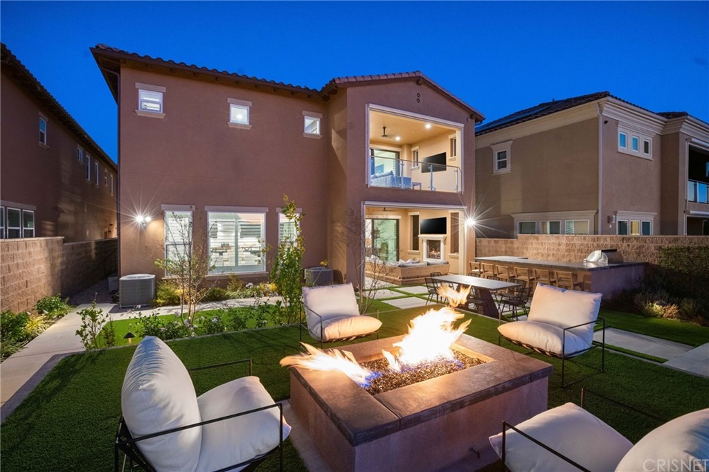 11907 Ancona Way Porter Ranch, CA 91326 - Photo 23 of 67 a view of a house with backyard sitting area and furniture