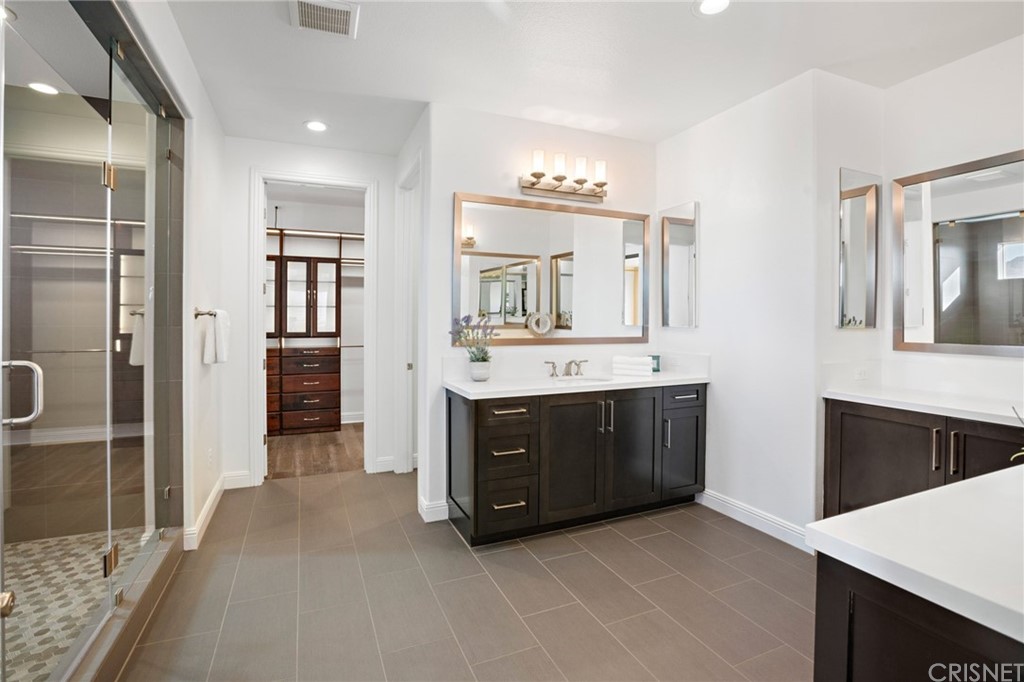 11907 Ancona Way Porter Ranch, CA 91326 - Photo 32 of 67 a spacious bathroom with a double vanity sink a mirror and shower