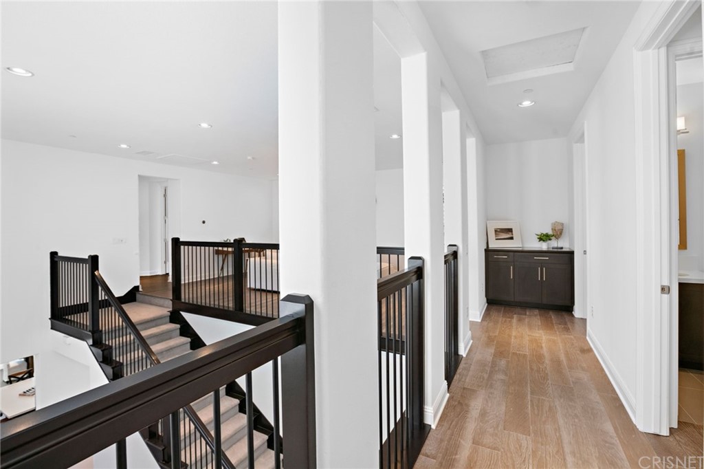 11907 Ancona Way Porter Ranch, CA 91326 - Photo 51 of 67 a view of a hallway with wooden floor and furniture