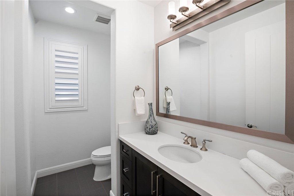 11907 Ancona Way Porter Ranch, CA 91326 - Photo 52 of 67 a bathroom with a sink a toilet and mirror