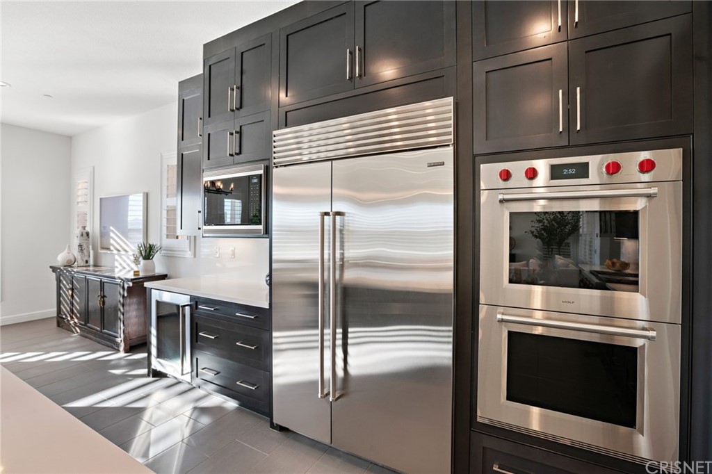 11907 Ancona Way Porter Ranch, CA 91326 - Photo 8 of 67 a kitchen with a refrigerator stove and microwave