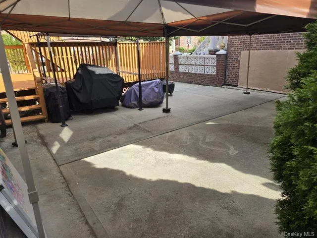 a backyard of a house with table and chairs under an umbrella