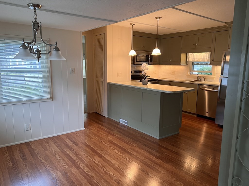 25 St James Circle Hudson, MA 01749 - Photo 5 of 15 a view of a kitchen with granite countertop stainless steel appliances and wooden floor