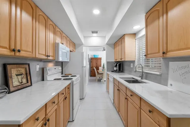 a kitchen with a sink a stove and cabinets