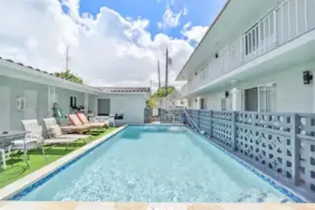 a front view of a house with swimming pool having outdoor seating