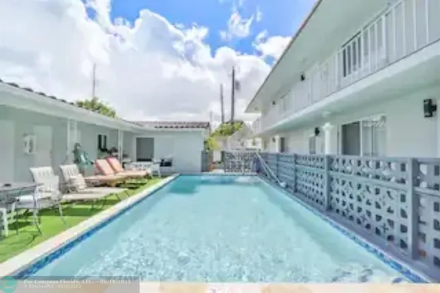 a front view of a house with swimming pool having outdoor seating