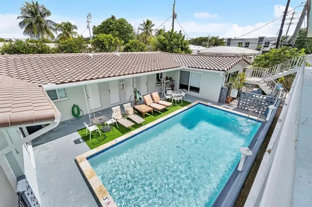 a view of a house with pool and chairs