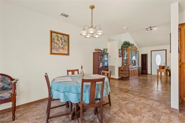 a view of a dining room and livingroom with furniture wooden floor a chandelier