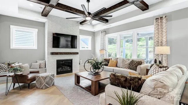 a living room with furniture a fireplace and a flat screen tv