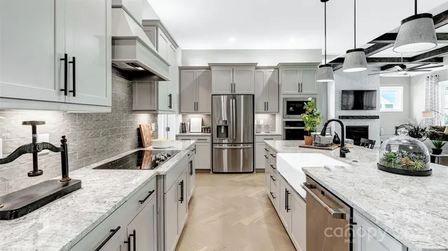 a kitchen with stainless steel appliances granite countertop a sink a stove and a refrigerator
