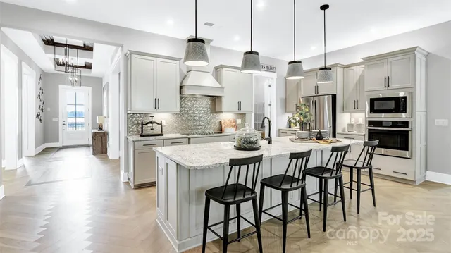 a open kitchen with stainless steel appliances granite countertop a sink a stove and a refrigerator