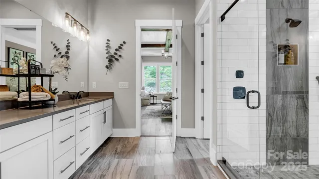 a bathroom with a granite countertop shower a mirror and a sink
