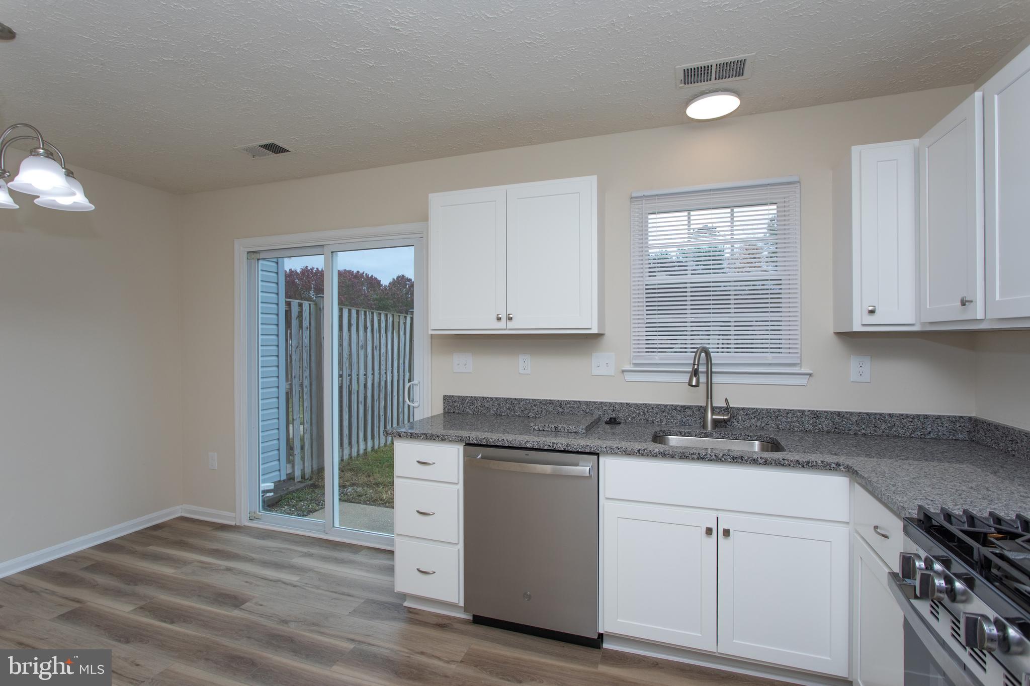 5704 Springfish Place Waldorf, MD 20603 - Photo 17 of 38 a kitchen with granite countertop white cabinets and white appliances