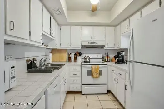 a kitchen with white cabinets and white appliances