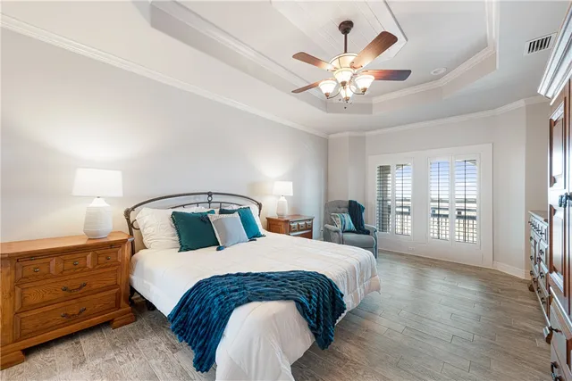 a bedroom with a large bed mirror and a chandelier