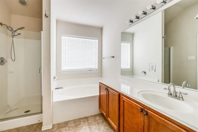 a bathroom with a granite countertop sink mirror and a bathtub