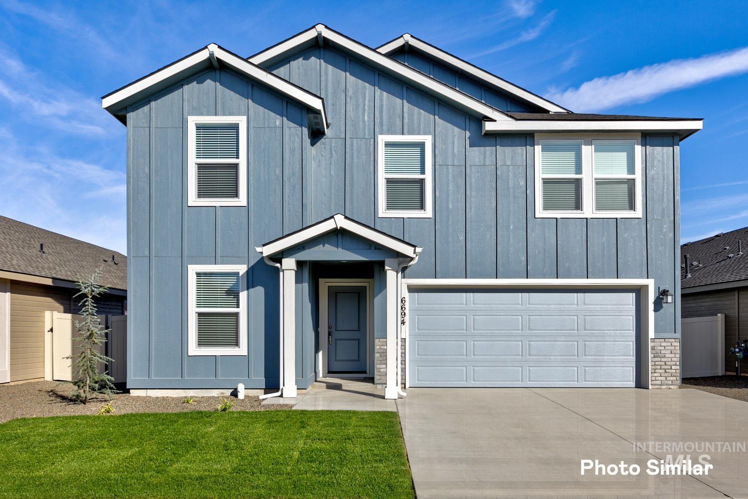9058 West Inspirado Street Meridian, ID 83646 - Photo 1 of 28 View of front of property featuring board and batten siding, an attached garage, driveway, and a front yard