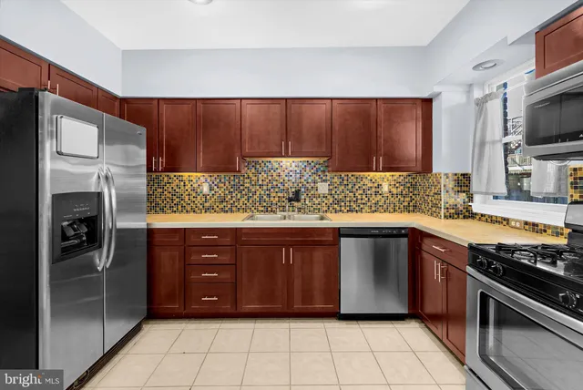 a kitchen with stainless steel appliances granite countertop a refrigerator and a sink