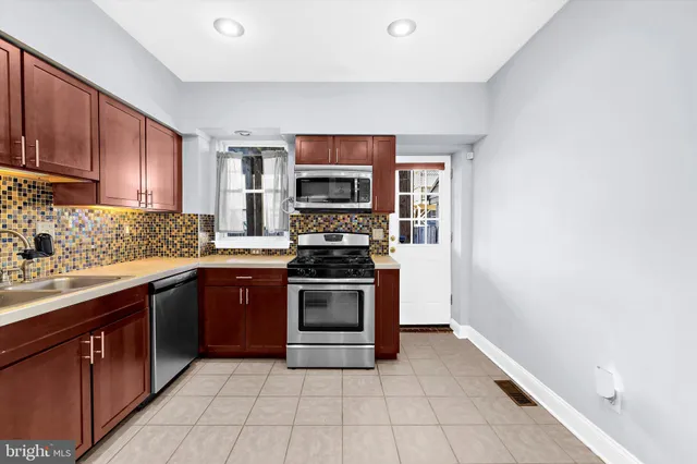 a kitchen with stainless steel appliances granite countertop a stove top oven a sink and dishwasher